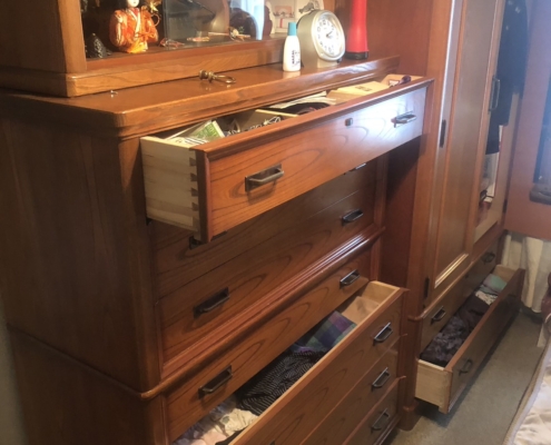 引き出しが開いた状態のタンスと日用品の整理風景｜不用品片付け 世田谷区