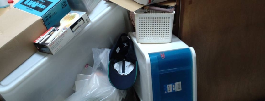 室内に積み上げられた段ボールや生活用品の片付け前の様子｜不用品片付け 渋谷区