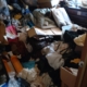 衣類や寝具が床一面に散乱したゴミ屋敷の室内｜ゴミ屋敷片付け 松戸市