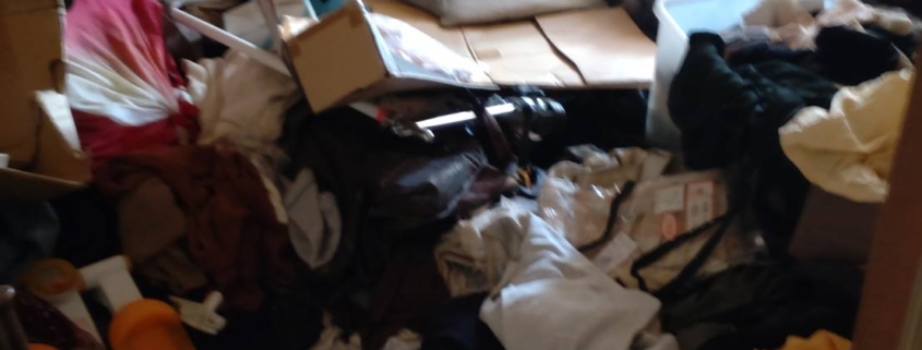 衣類や寝具が床一面に散乱したゴミ屋敷の室内｜ゴミ屋敷片付け 松戸市
