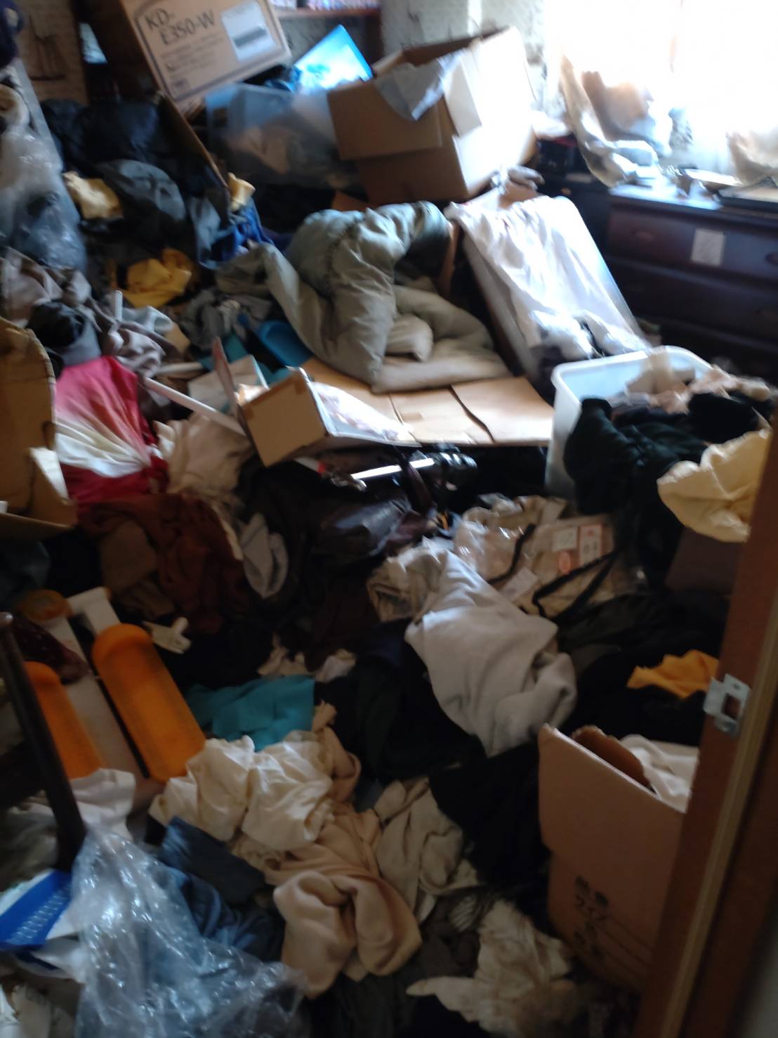 衣類や寝具が床一面に散乱したゴミ屋敷の室内｜ゴミ屋敷片付け 松戸市