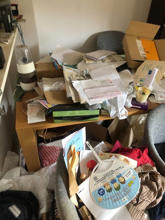 机上に溢れた書類や紙類を仕分けしている様子