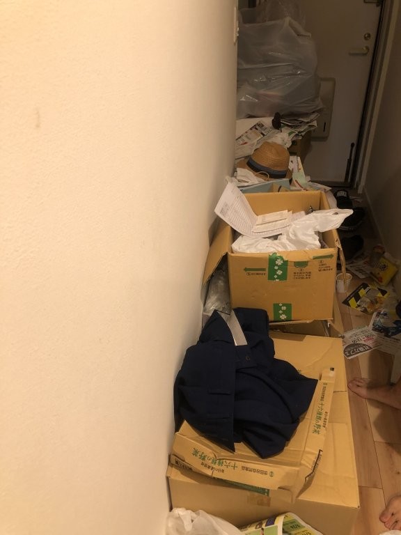 廊下に積まれた段ボールを整理している様子